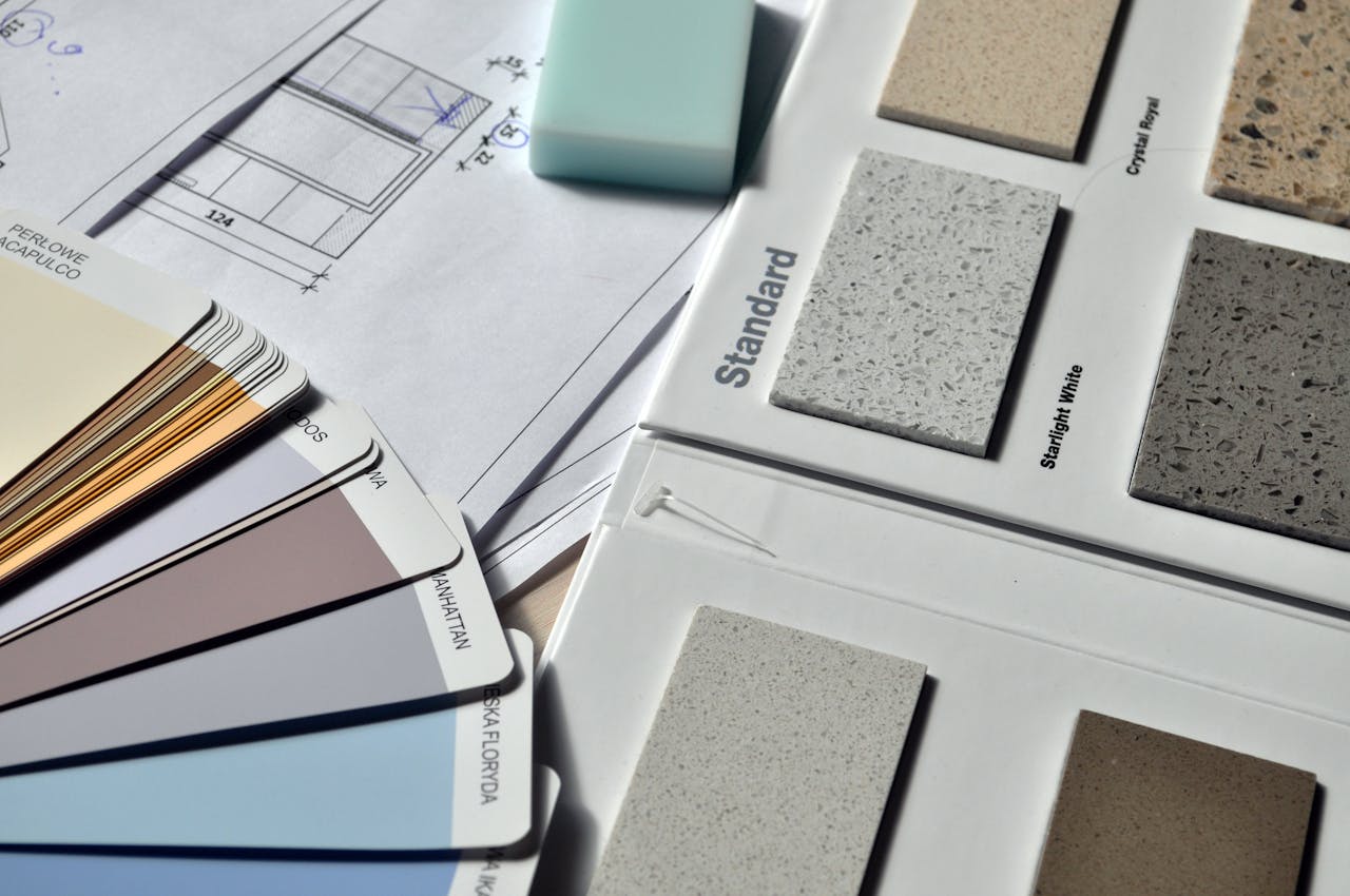 Services Color palette and material samples for interior renovation projects on a blueprint.